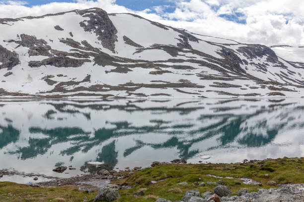 istock snow mountains surrounded by clouds in norwegian fiord reflection in water selective focus 1211648389