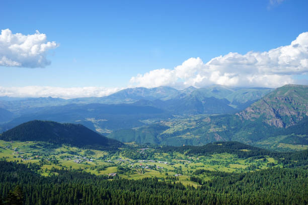 High angle view of green mountain range landscape over sunny blue sky with white clouds in Rize, Turkey