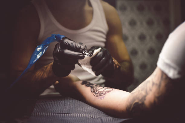 istock Artist tattooing a man in studio 1211652715