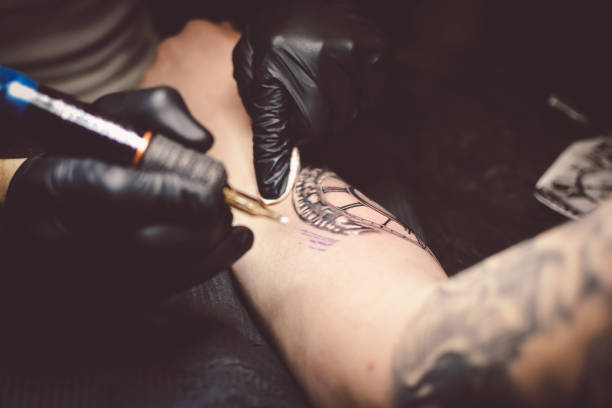 istock Artist tattooing a man in studio 1211652804