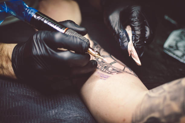 istock Artist tattooing a man in studio 1211652866