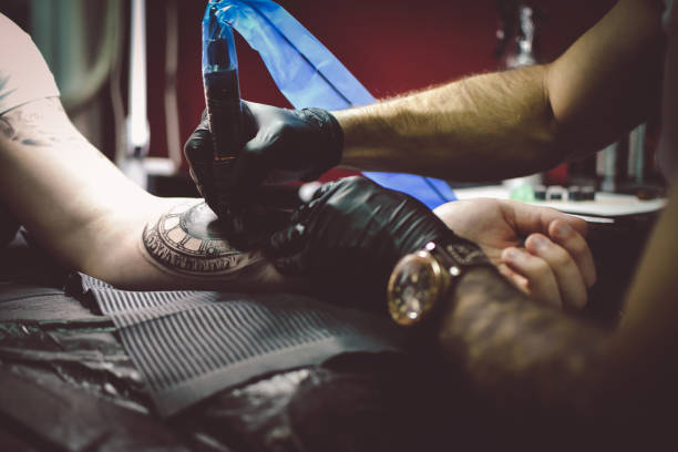 istock Artist tattooing a man in studio 1211653969