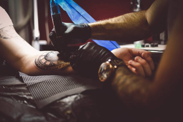 istock Artist tattooing a man in studio 1211654544