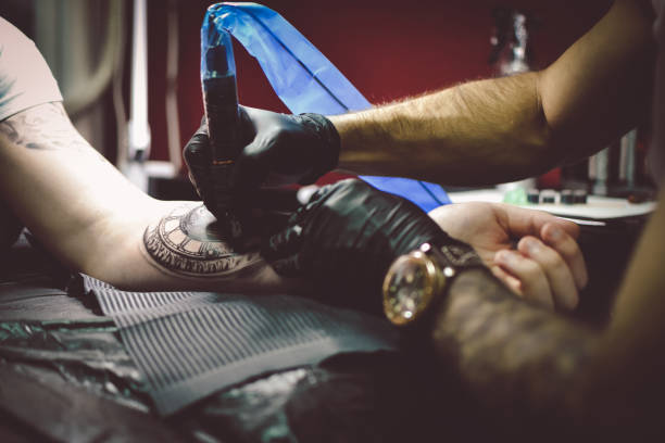 istock Artist tattooing a man in studio 1211654598