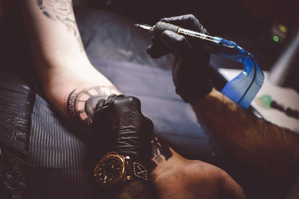 istock Artist tattooing a man in studio 1211654678