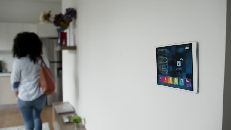 Black woman leaving apartment and setting the lock form tablet