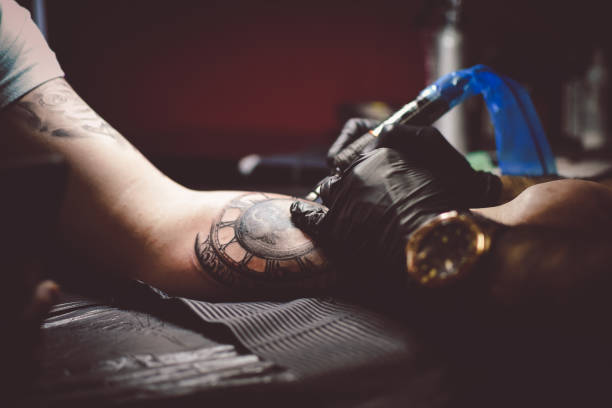istock Artist tattooing a man in studio 1211654874