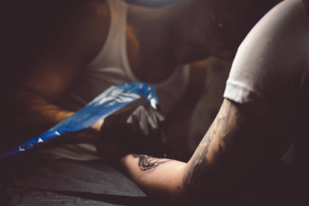 istock Artist tattooing a man in studio 1211655655