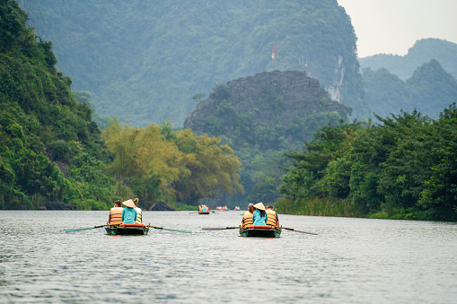 Ninh Binh, Vietnam - march 1006, 2020 : Tourist boat trip on Ngo Dong river in Trang An Hang Mua, Vietnam. Beautiful nature of North Vietnam near Hanoi