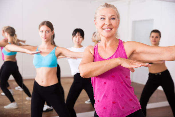 istock Group of active smiling people dancing together in dance studio 1211661172