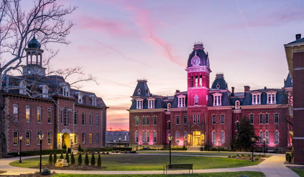 Woodburn Hall at West Virginia University in Morgantown WV Dramatic image of Woodburn Hall at West Virginia University or WVU in Morgantown WV as the sun sets behind the illuminated historic building campus stock pictures, royalty-free photos & images