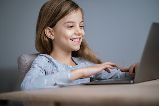 Smiling girl is using laptop to searching on internet