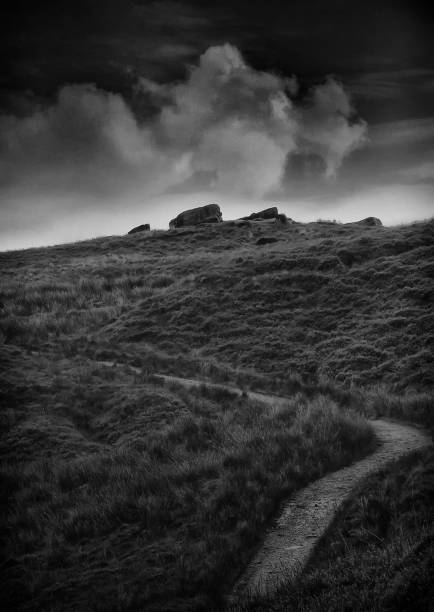 istock atmospheric dark twilight landscape with a narrow winding hillside pathway in rugged yorkshire moorland with grass and storm clouds 1211663905