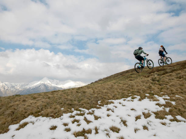 istock Mountain bikers ride up snowy ridge line 1211664830