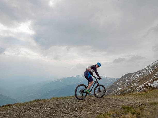 istock Mountain biker rides along snowy ridge line 1211664895
