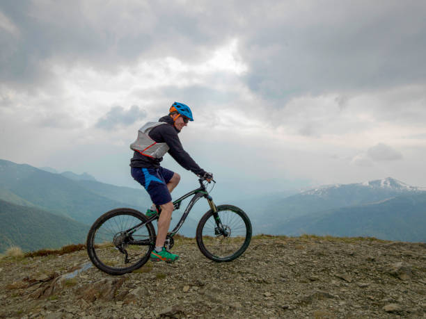 istock Mountain biker rides along snowy ridge line 1211664898