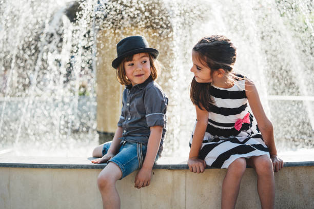 Kiev: Happy children playing in a water fountain and enjoying the cool streams of water in a hot day