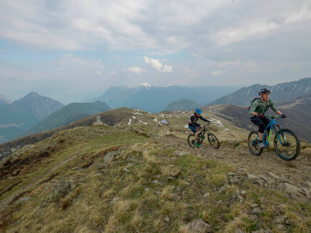 istock Mountain bikers ride up snowy ridge line 1211664960