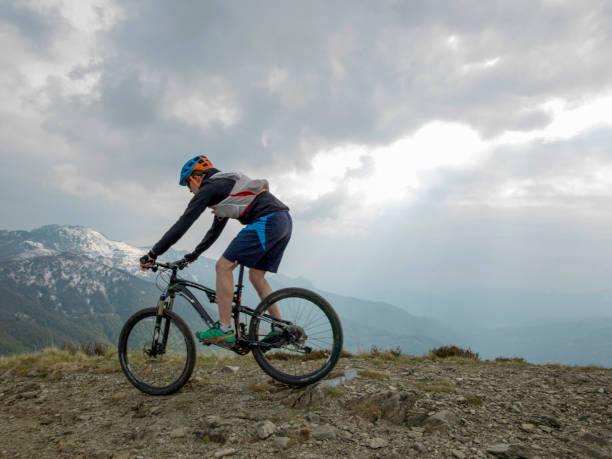 istock Mountain biker rides along snowy ridge line 1211665081