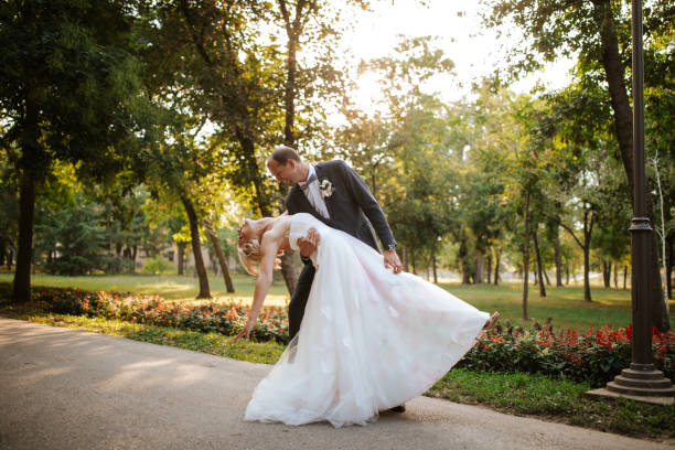 istock Happy bride and groom dancing in park 1211668403