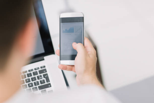 istock rear view. business men checking financial data 1211671362