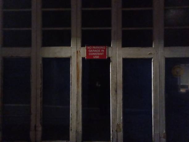 istock No Parking Sign on Garage Doors at Night 1211675182