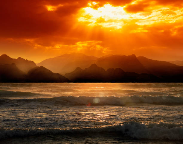 seascape image with high mountains over cloudy orange color sunset in Antalya, Turkey