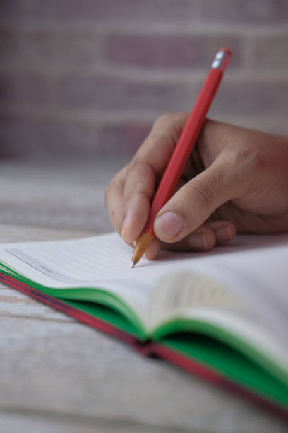 istock close up of women hand writing on notepad 1211685760