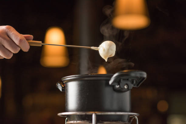 ser fondue z gorącą patelnią i ręką - kociołek zdjęcia i obrazy z banku zdjęć