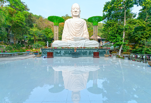 Vung Tau, Vietnam - December 22nd, 2019: Big buddha statue meditating in front of temple yard. This is a place where spirituality prays for everyone to lead a peaceful life in Vung Tau, Vietnam