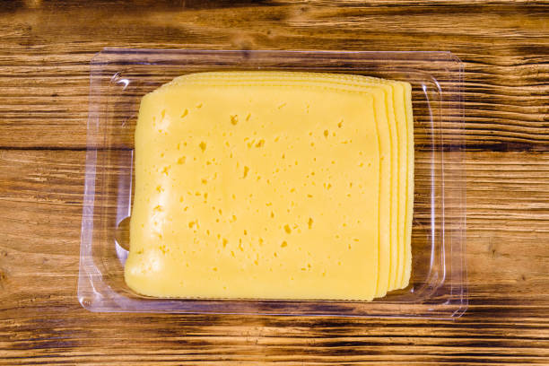 istock Sliced cheese and parsley in plastic container on wooden table. Top view 1211690117