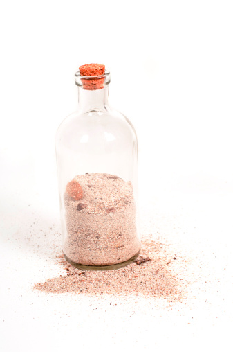 Shot of bottle with sand isolated on white