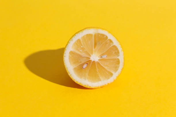 istock Lemon half with seeds on yellow background. 1211691563
