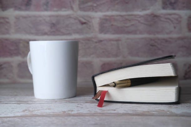 istock tea cup, fountain pen and open diary on table 1211694360
