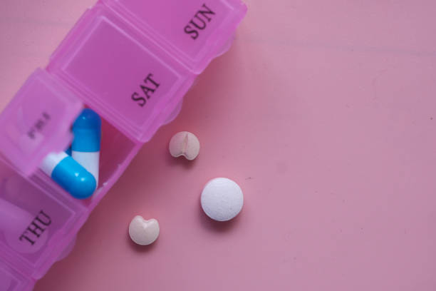 istock multi color pills in a pill box on pink background 1211694650