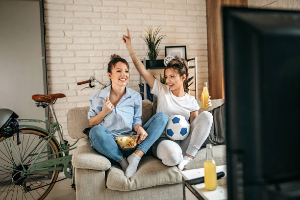 istock Roommates watching sport on tv, cheering 1211696984