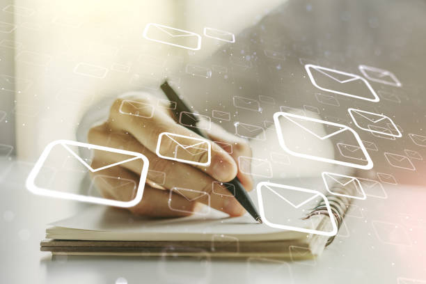 istock Double exposure of postal envelopes hologram with hand writing in notebook on background. Electronic mail and spam concept 1211700568