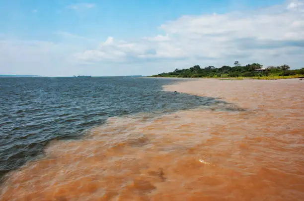 Meeting of the waters of the Rio Negro and Rio Solimoes Rivers in front of Manaus port in Brazil.