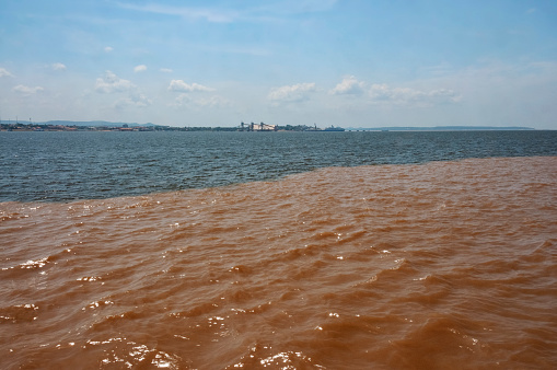 Meeting of the waters of the Rio Negro and Rio Solimoes Rivers in front of Manaus port in Brazil.