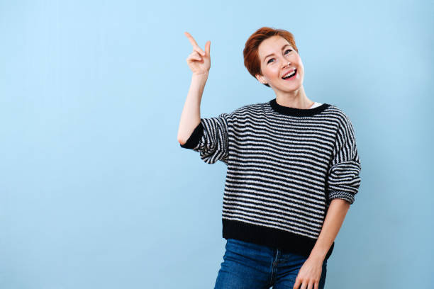 istock Cheerful girl with short ginger hair making gestures with her hand 1211706174