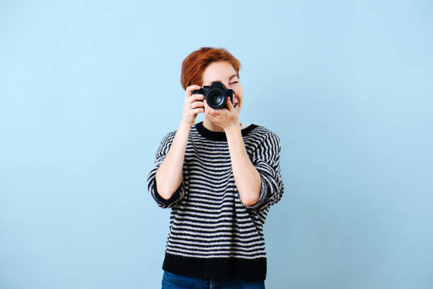istock Cheerful middle aged woman with short ginger hair taking camera shot. 1211706176