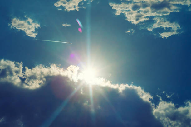 The sun shines bright in summer. Blue sky and clouds.- image toned