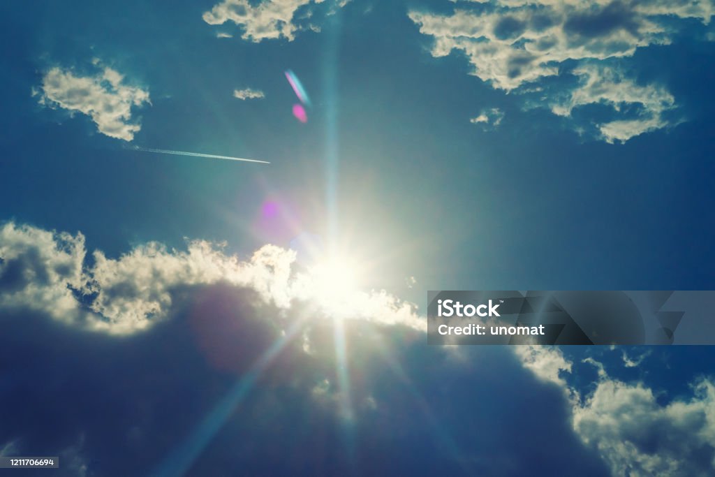 The sun shines bright in summer. Blue sky and clouds. The sun shines bright in summer. Blue sky and clouds.- image toned Heat - Temperature Stock Photo