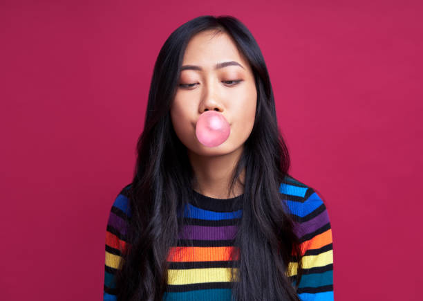 istock Pretty young woman blowing bubble with chewing gum 1211711671