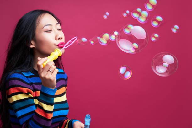 istock Happy beautiful woman blowing soap bubbles 1211711686