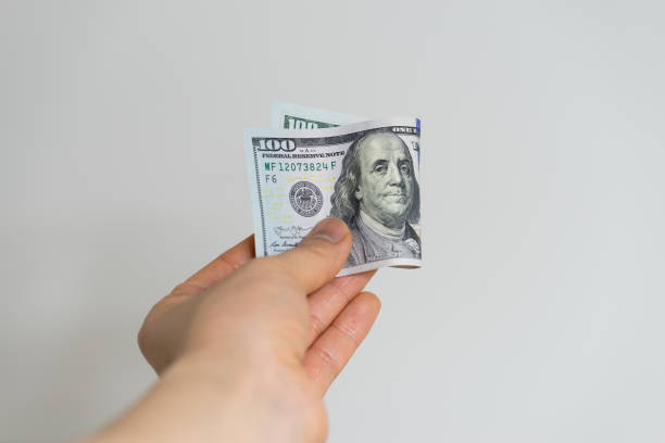 istock Hand holding a one hundred dollar bill 1211714011