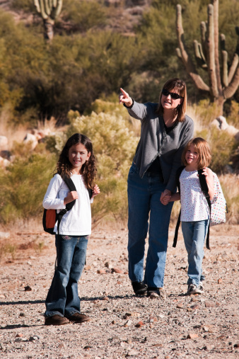 Stock photo of a mom with her daughter and daughters' friend out for a nature walk in a desert landscape.  Shot at the DesertLypse 4.