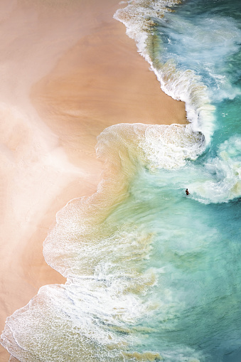 View from above, stunning aerial view of a beautiful beach bathed by a turquoise sea during sunset. Kelingking beach, Nusa Penida, Indonesia.