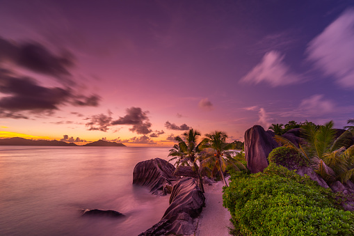 peaceful evening on beautiful tropical seychelles island after sunset with colorful sky and calm sea, long exposure