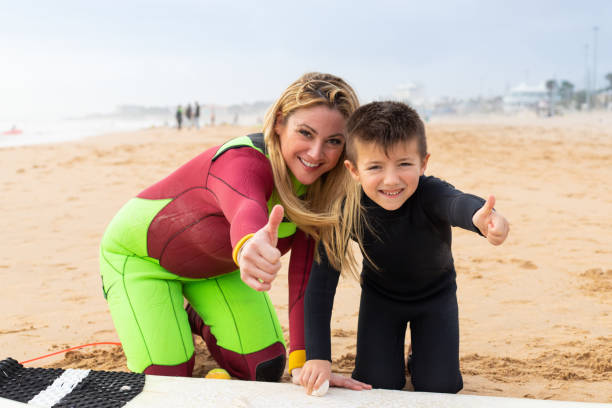 istock Mother and son in wetsuits showing thumbs up 1211721643